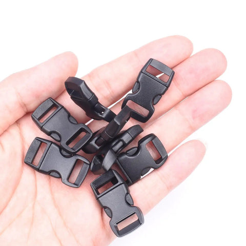 Hand holding several 100 Pack Three Eighths Inch Curved Contoured Plastic Quick Side Release Buckles For Paracord Bracelets Dog Collars Masks And DIY Straps Durable POM Buckle Clips For Easy Clasp And Replacement in black.