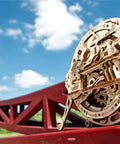 Mechanical Monowheel 3D Puzzle Kit Unicycle Style Wooden Steampunk Build For Adults Self Rolling Brain Teaser Model Kit Made Of Wood Family Friendly Craft Set Hands On Fun And Mental Challenge wooden monowheel on red bridge