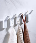 No Mess Punch Free Wall Mounted Robe Hooks Top Shelf Aluminum Towel Rack holding white and brown towels on a smooth wall.