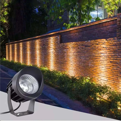 AC85‑265V IP65 Rotatable LED Flood Light (Green 25w) illuminating a brick wall in a landscaped garden.
