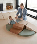 Toddler Tested Indoor Play Arena Featuring Super Soft Foam Climb Blocks, green and brown foam shapes with a toddler and adult.