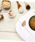 Top view of bread maker with Stirring Paddle Replacement For Bread Maker No Fuss Kneading Paddle next to ingredients on table.