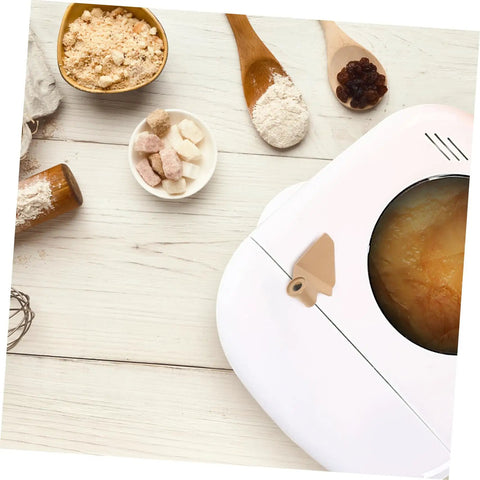 Top view of bread maker with Stirring Paddle Replacement For Bread Maker No Fuss Kneading Paddle next to ingredients on table.