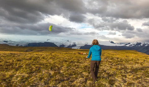 Person flying Synapse 140 Dual Line Parafoil Kite For Beginners And Modern Flyers, Easy Setup And Quick Pack in windy landscape.