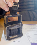 Heavy Duty Self Inking Date Stamp Built Tough For Busy Shops And Stores Runs Smooth With Zero Mess covering a document.