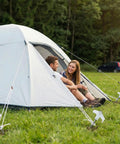 Tent secured by 12 Pack 8 Inch Heavy Duty Screw In Tent Stakes Glow In The Dark Ground Anchors with people sitting outside.