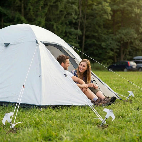 Tent secured by 12 Pack 8 Inch Heavy Duty Screw In Tent Stakes Glow In The Dark Ground Anchors with people sitting outside.