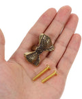 Copper Bowknot Cabinet Handle And Drawer Pull Kit In Vintage Brass Finish held in hand with screws for installation