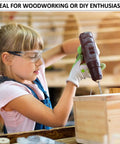 Young girl using power drill on wooden box wearing safety goggles, ideal for woodworking and DIY enthusiasts.