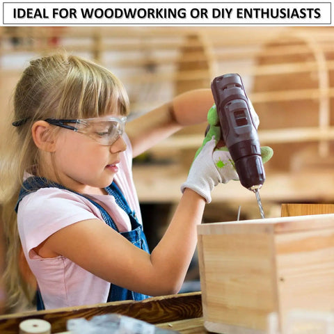 Young girl using power drill on wooden box wearing safety goggles, ideal for woodworking and DIY enthusiasts.