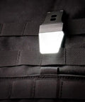 White LITE Hands Free LED Pocket Light With USB Rechargeable Power, 20 100 200 Lumens, clipped on black MOLLE webbing.
