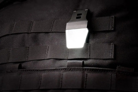 White LITE Hands Free LED Pocket Light With USB Rechargeable Power, 20 100 200 Lumens, clipped on black MOLLE webbing.