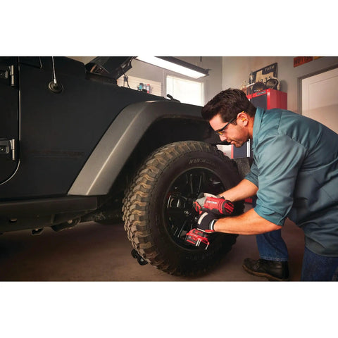 Person using Beast Half Inch Cordless Impact Wrench Bare Tool With Hog Ring Anvil on car tire in garage