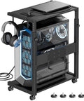 Boss Level Adjustable PC Tower Stand With Charging Station For Office Home Classroom Fits 23 To 28 Inch Towers Black Dual 120V Sockets And USB Ports CPU Holder Cart with a PC tower and headphones. Visible charging cords and adjustable rack.