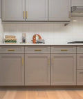 Kitchen cabinets with gold stainless steel cabinet pulls, square drawer handles set of 2, installed on grey doors.