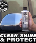 Hand holding Heavy Metal Polish Restorer and Protectant for Chrome Aluminum Stainless Steel Brass Silver and more near car mirror