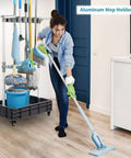 Grab-And-Go Mobile Broom And Mop Organizer Cart With Drying Hooks in use, woman cleaning floor in home setting, tools organized