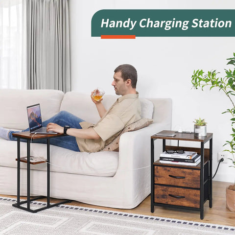 Compact Nightstand With Charging Station And USB Ports beside a man relaxing on a sofa, featuring fabric drawers and storage shelf.