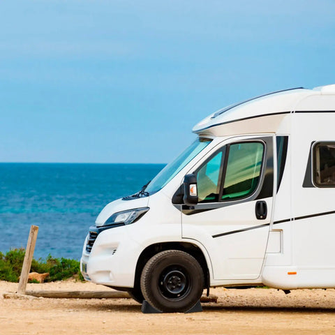 Heavy Duty Rubber Wheel Chocks Four Pack For RVs And Trailers, Tough As Nails Grip beneath RV parked at beachside