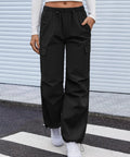 Women's Cargo Hiking Pants With Elastic Waist, Water Resistant Quick Dry Parachute Style Baggy Fit, Black Size M on model.