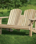 Adirondack-style outdoor bench made of light wood, featuring slatted backrest and armrests on a green lawn.