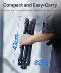 Person holding a folded Extendable 6.23ft Aluminum Light Stand For Photography, Reversible Portable Studio Tripod, 43cm compact size.
