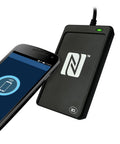 USB NFC Go To Reader And Writer For Windows Mac Linux with PC linked peer-to-peer, black, alongside smartphone.