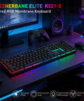 Dope Full Size Gaming Keyboard With Quick Turn Volume Knob, 104 Keys Wired PC Peripheral Featuring Fresh RGB Lighting And Crisp Feedback For Weekend Warriors on a gaming desk with glowing RGB lights.