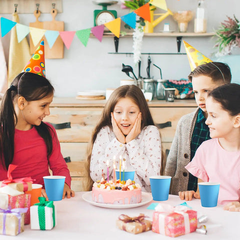 Kids at a birthday party with Sturdy 5oz Disposable Paper Cups Bulk 1200 Pack For Cold Drinks on a table with a cake.