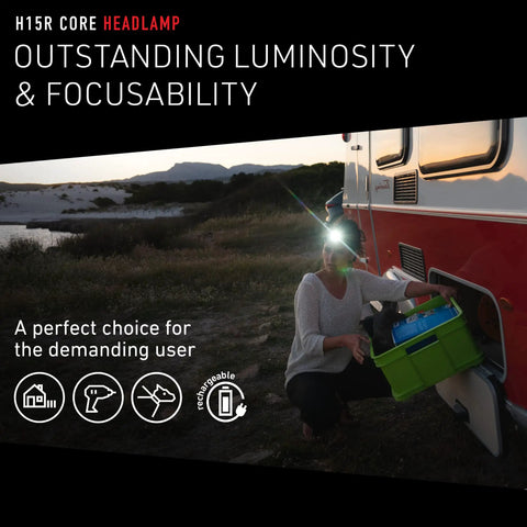 Person using H15R Core Headlamp 2500 Lumen Helmet Light With Advanced Focus System, lighting up campsite from trailer.