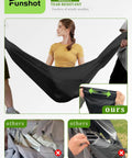 Woman testing tear resistance of black waterproof double egg chair cover for outdoor hanging swing seats, 91 by 80 inches.