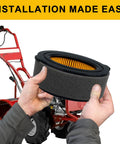 Panari air filter with yellow pleated element and black foam housing, held by hands with a red lawn tractor in background.