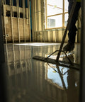 Worker applying No Sweat Setup Self Leveling Concrete Underlayment 50 Lb Bag on smooth interior floor.