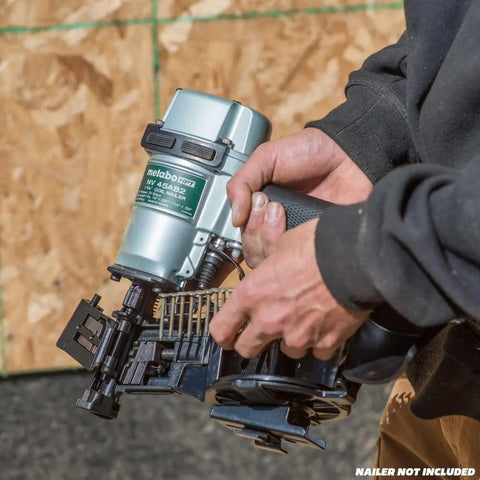 Hands holding a nailer with a coil of One And Three Quarters Inch Full Round Head Roofing Nails With Smooth Shank Electro Galvanized