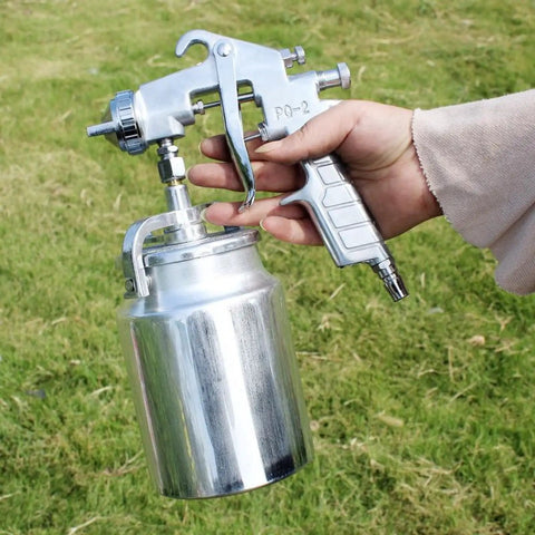 Person holding suction type paint spray gun with 2.0mm nozzle, handheld pneumatic sprayer, built tough rustproof build