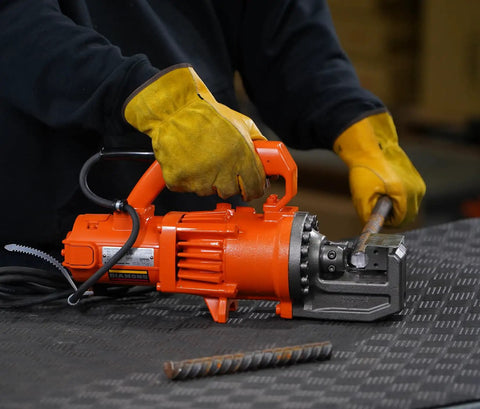 Benner Nawman Dc-20Wh Portable Heavy-Duty Rebar Cutter in use, cutting a 3/4 inch steel reinforcing bar on a job site.