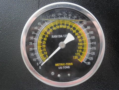 Close-up of precise pressure gauge on Heavy Hitting 75 Ton Air Hydraulic Shop Press with metrics and calibration markings.
