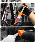 Hydraulic Bike Brake Bleed Kit For Shimano, SRAM, Tektro, And Magura, syringe detail with orange fittings in use