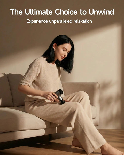 Woman using Mini Massage Gun With Heat For Deep Tissue Relief in living room, relaxing on sofa, showcasing ergonomic design for home use.