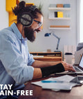 Man using a laptop wearing Unisex Adjustable Wrist Brace For Carpal Tunnel Relief With Day And Night Support, Universal Fit.