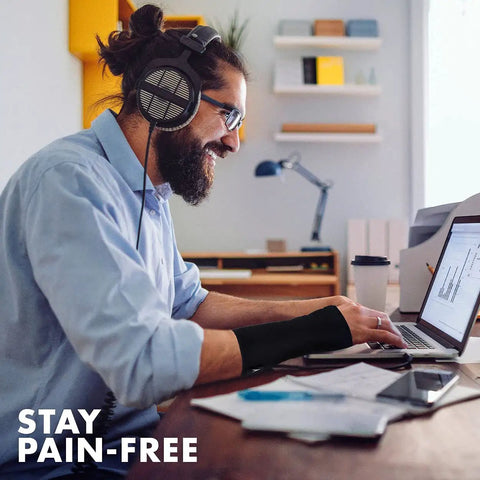 Man using a laptop wearing Unisex Adjustable Wrist Brace For Carpal Tunnel Relief With Day And Night Support, Universal Fit.