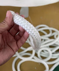 Person holding a white Graphite Impregnated Fiberglass Rope Seal Gasket For Wood Stoves 14mm By 2m White Replacement Heat Resistant Door Seal.