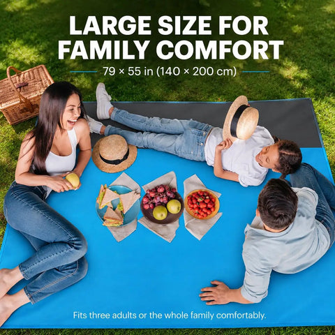 Family enjoying a picnic on a Sandproof Waterproof Beach Blanket, Extra Large 79x55 Inch Outdoor Mat For 1-4 Adults in aqua blue.
