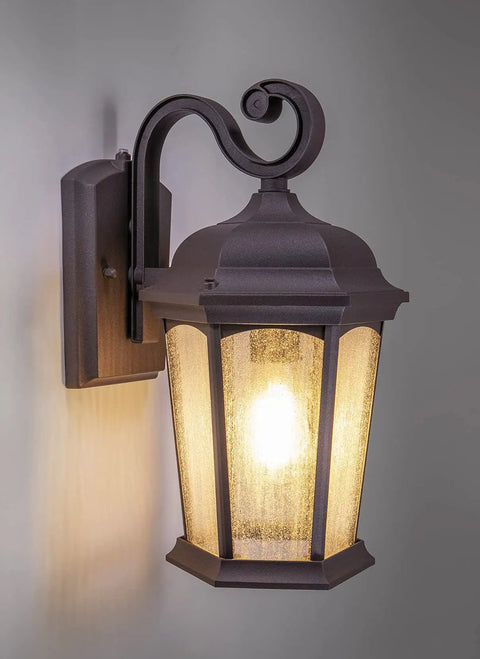 Outdoor Hex Wall Lantern Dusk To Dawn Sensor in Rustic Bronze Cast Aluminum with Seeded Glass Wet Location Rated Photocell Auto On At Night Durable Weatherproof Build With Moisture Blocking Rubber Washers and Five Year Warranty