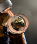Solid bronze bottle opener lifting a beer cap, showcasing 7 Piece Bulk Metal Bottle Opener Inserts And Blanks For Wood Turning DIY Craft Projects Solid Bronze Threaded Beer Hardware Parts Ready To Whip Up Some Sick Custom Gear And Wedding Favors.