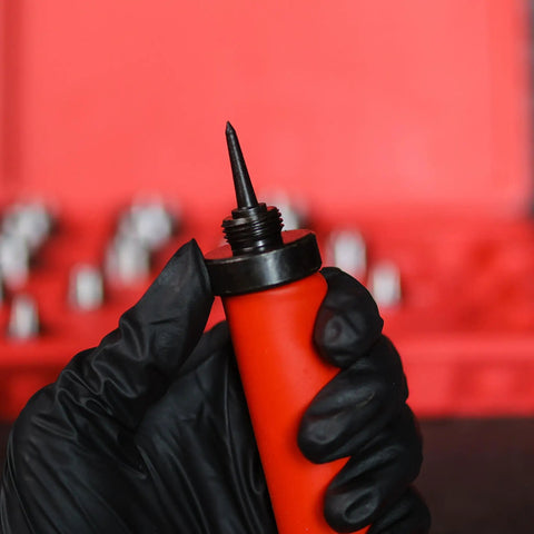 Close-up of hand in glove holding punch tool from Pro Grade Hollow Punch Kit For Leather And Gasket Making, 13-in-1 Hole Punch Set.