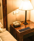 Recessed Power Strip With USB Ports And 10W Wireless Charging Station For Desk Or Table Two Outlets And Dual USB Ports UL Listed Furniture Power Hub For Sofa Table Cabinet Or Drawer With A 6.56 Foot Cord installed on a bedside table with lamp