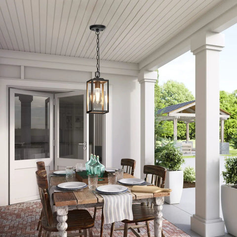 Modern Outdoor Pendant Light With Rock Solid Aluminum Build And Clear Glass Panel, hanging in a covered patio dining area.