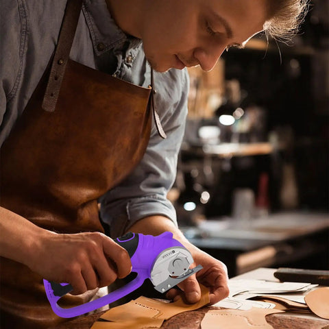 User cutting leather with Heavy Duty Cordless Electric Scissors 4V Rechargeable Rotary Cutter for crafts.