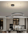 Modern Large Black Aluminum Circle Pendant Light Sleek Ceiling Lamp For Living Room And Kitchen Dining hanging above a stylish kitchen island.
